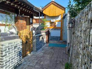 a house with a fence and a brick alley at Jeonju Sanyacho Pension in Jeonju