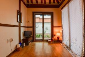 a living room with a large window and a television at Jeonju Sanyacho Pension in Jeonju