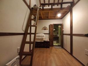 a loft bed in a room with a ladder at Jeonju Sanyacho Pension in Jeonju +21 photos
