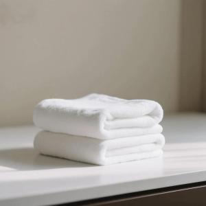 three white towels sitting on a counter in a bathroom at Heavens Gate homestay free pick up service from train station and airport in Zhangjiajie +34 photos