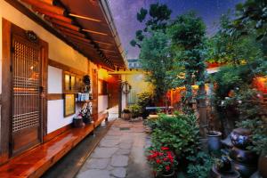a courtyard of a building with flowers and plants at Kkot Jari Hanok Pension in Jeonju