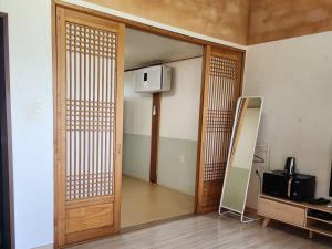 a room with a wooden door and a television at Unyujae Hanok Pension in Yeongam
