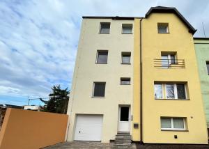 a yellow building with two white garage doors at Apartmán NIKA Choceň in Choceň