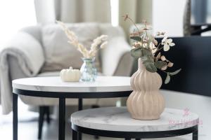 a table with a vase and a table with two chairs at Your Holidays Waves Panorama D866 in Międzyzdroje +34 photos