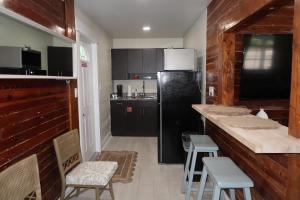 a kitchen with a black refrigerator and some chairs at The Elizabeth Suite in Key West