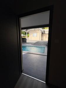 a door leading to a swimming pool through a doorway at Studio- Rémire-Montjoly in Montjoly +1 photo