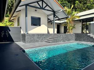 a swimming pool in front of a house at Studio- Rémire-Montjoly in Montjoly