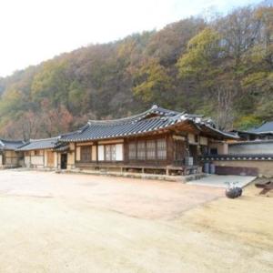 an asian style building in front of a mountain at Chungsong Chalbang Gongjongtaek Pension in Cheongsong