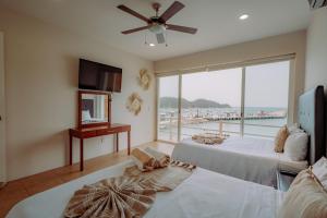 a bedroom with two beds and a large window at La Playa Suites in Santa Cruz Huatulco