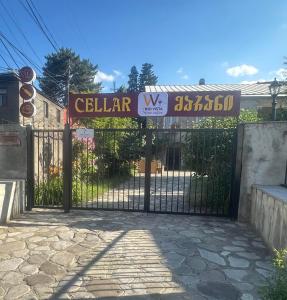 a gate to a building with a sign on it at Vino Vista in Tʼelavi