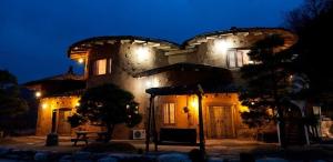 Un gran edificio con luces por la noche. en Punggi Red Clay Pension, en P'unggi