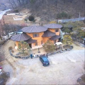 una casa con un coche aparcado delante en Punggi Red Clay Pension, en P'unggi