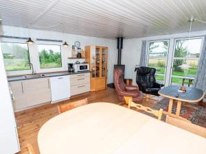 a kitchen and dining room with a table and chairs at 6 person holiday home in Thyholm in Thyholm +24 photos