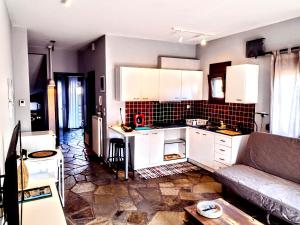 a kitchen with white cabinets and a couch in a room at MickeyHouse in Agria
