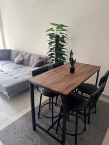 a table and chairs in a living room with a couch at Modern Apartment in Boshar, Muscat in Muscat