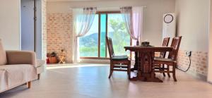 a living room with a table and chairs and a window at Namhae Sunset Pension in Namhae
