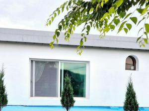 a white house with trees in front of it at Namhae Sunset Pension in Namhae