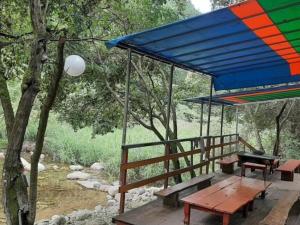 a deck with a picnic table and a colorful umbrella at Hanok Pension Wonju Chiak Moutain in Wonju