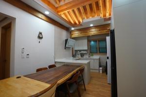 a kitchen with a wooden table and a dining room at Yeongam Nangjuwon in Yeongam