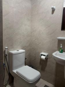 a bathroom with a toilet and a sink at Modern Apartment in Boshar, Muscat in Muscat