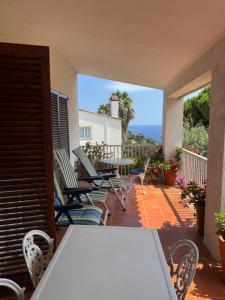 a table and chairs on a patio with a view of the ocean at Apartamentos Escorpion Tossa de Mar in Tossa de Mar
