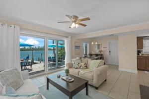 Una sala de estar con un sofá y un ventilador de techo. en Coastal Breeze Siesta Manatee "C", en Sarasota