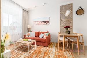 a living room with a red couch and a table at Your Holidays Bel Mare Aqua 537F in Międzyzdroje +19 photos