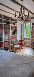 a bedroom with a bed and a chair and bookshelves at Château de Longevergne in Anglards-de-Salers