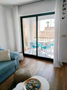 salon z niebieską kanapą i balkonem w obiekcie CABALLITO DE MAR w mieście Los Alcázares