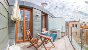 een balkon met een tafel en stoelen op een balkon bij Modern Apartment Charvátova in Praag
