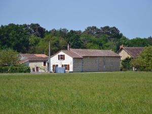 a white house in a field next to a grass field at Maison de campagne avec jardin privé, proche Châteaux de la Loire et Futuroscope. - FR-1-381-288 in Chaveignes