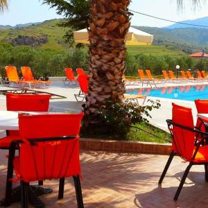 un gruppo di sedie rosse sedute accanto alla piscina di Hotel Marilena a Mythimna