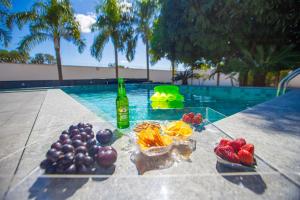 a table with fruit on it next to a swimming pool at Refúgio 4 Suítes c/ Piscina, Sinuca e Área Gourmet in Caldas Novas