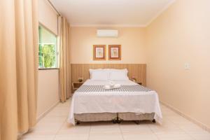 a bedroom with a bed and a window at Refúgio 4 Suítes c/ Piscina, Sinuca e Área Gourmet in Caldas Novas +25 photos