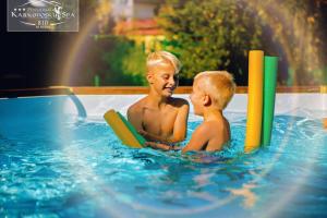 dwóch młodych chłopców bawiących się w basenie w obiekcie Karkonoski SPA - Bufet mini All Inclusive gratis! w mieście Karpacz