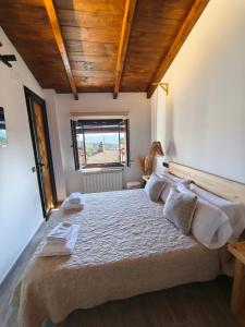 a bedroom with a large bed with wooden ceilings at La Cabaña27 in La Alberca