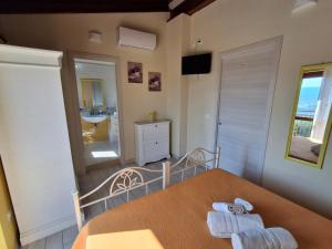 a bedroom with a bed and a bathroom with a sink at Colle Del Mirto in Castelnuovo Cilento