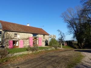 Beaune dʼAllierにあるFermette rénovée avec charme, animaux acceptés, connexion Internet - FR-1-489-246の道路沿いにあるピンクのドアが付いた古い石造りの家