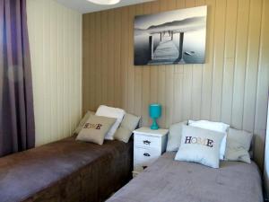 a bedroom with two beds with pillows and a night stand at Gîte cosy avec terrasse, climatisation et parking - Meillard - FR-1-489-267 in Meillard