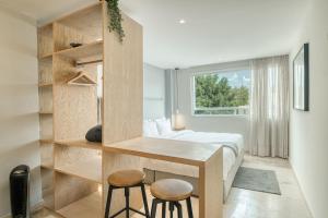 Un dormitorio con una cama y un escritorio y una ventana. en Nido Roma, en Ciudad de México