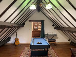 a room with a ping pong table in a attic at Charme authentique et moderne dans une longère bourbonnaise - FR-1-489-397 in Hyds