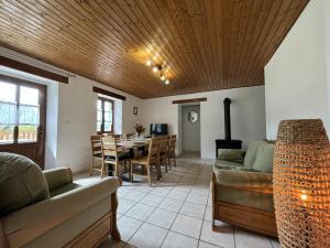 ein Wohnzimmer mit Sofa und Tisch in der Unterkunft Maison chaleureuse avec spa en montagne bourbonnaise - FR-1-489-534 in La Chabanne