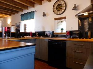 a large kitchen with a large clock on the wall at Ferme rénovée du 19e avec grande terrasse, charme et confort en pleine nature - FR-1-489-392 in Lurcy-Lévis +10 photos