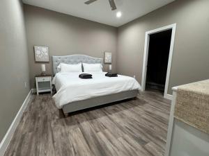 a bedroom with a large white bed with a wooden floor at Peace in the Garden - Home in Winter Garden in Orlando +13 photos