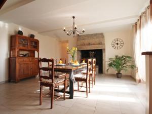 una sala da pranzo con tavolo, sedie e camino di Maison de charme avec jardin et équipements bébé, près de la forêt d'Écouves - FR-1-497-16 a Rouperroux