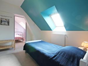 una camera da letto con un letto blu e una finestra di Maison de charme avec jardin et équipements bébé, près de la forêt d'Écouves - FR-1-497-16 a Rouperroux