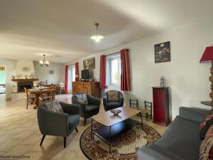 Una sala de estar con un sofá y sillas y una mesa. en Maison de campagne avec jardin clos, cheminée et animaux, au cœur du Parc Régional du Perche - FR-1-497-91, en La Chapelle-Souëf