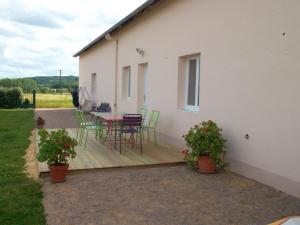 una terraza de madera con mesa y sillas en una casa en Maison de campagne avec jardin clos, cheminée et animaux, au cœur du Parc Régional du Perche - FR-1-497-91, en La Chapelle-Souëf