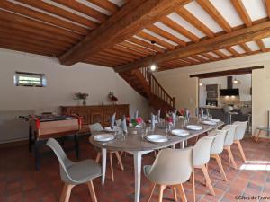 una grande sala da pranzo con un lungo tavolo e sedie di Maison de charme avec grand jardin, jeux pour enfants, et équipements modernes à Merri - FR-1-497-137 a Merri