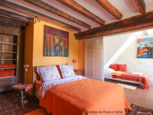 une chambre avec un lit avec une couverture orange dans l'établissement Maison de charme avec piscine chauffée et wifi au cœur du Perche - FR-1-497-186, à Appenai-sous-Bellême 28 autres photos